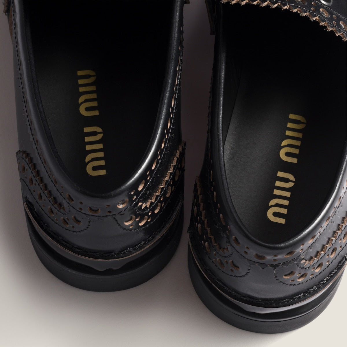 Black leather loafers with gold coin detail