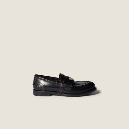 Black leather loafers with gold coin detail