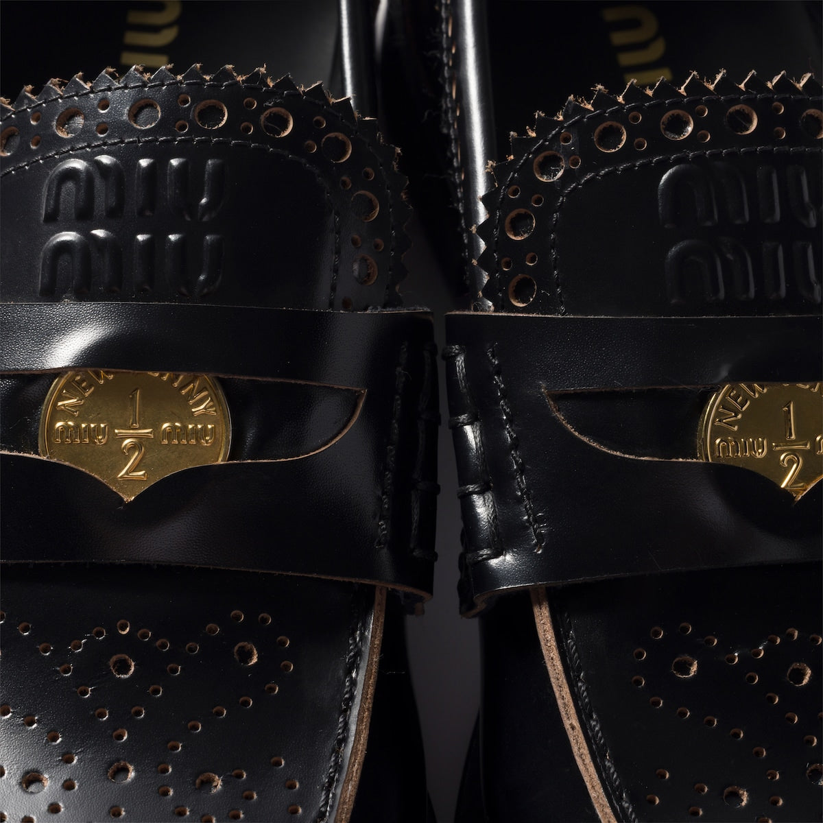Black leather loafers with gold coin detail