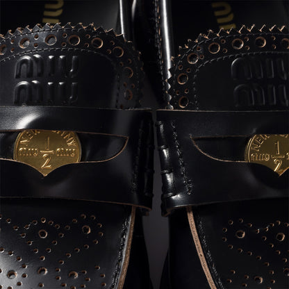 Black leather loafers with gold coin detail